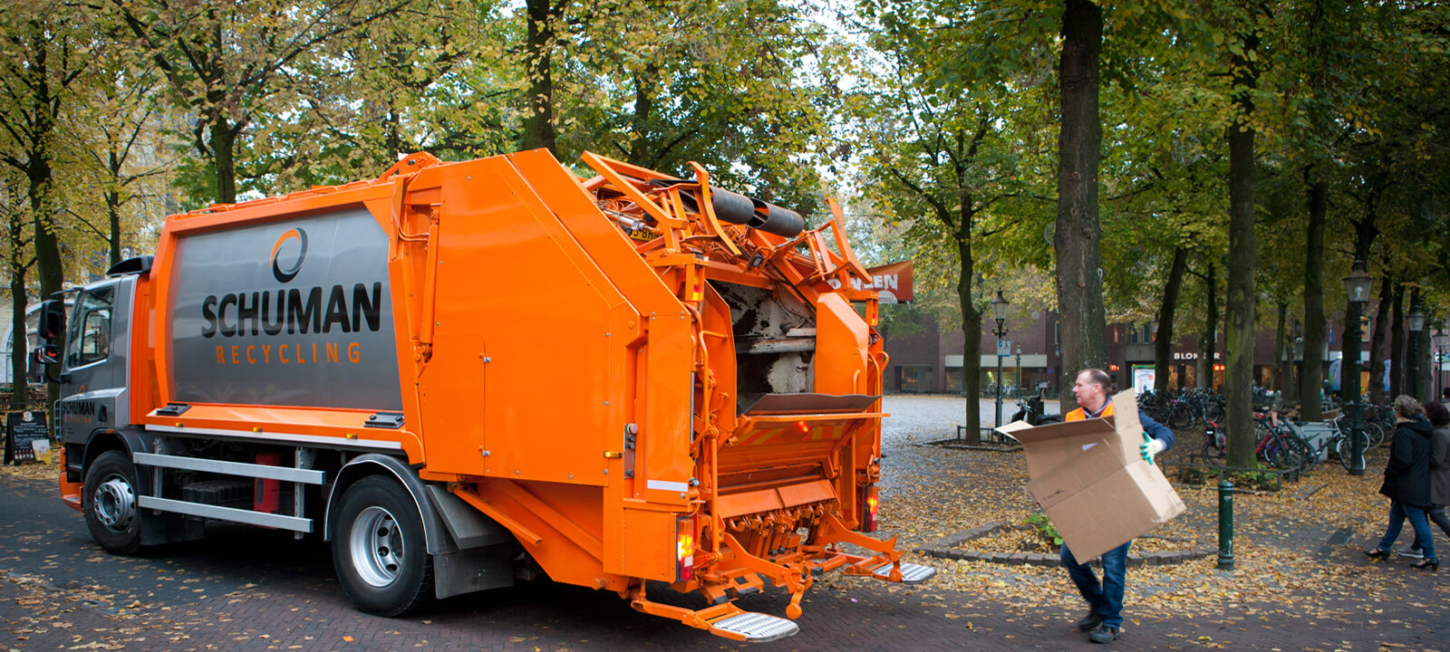 Oranje perswagen van Schuman Recycling onderweg in Limburg