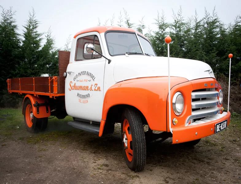 De oranje-witte Schuman & Zn. oud-papierwagen uit Roermond, 1930
